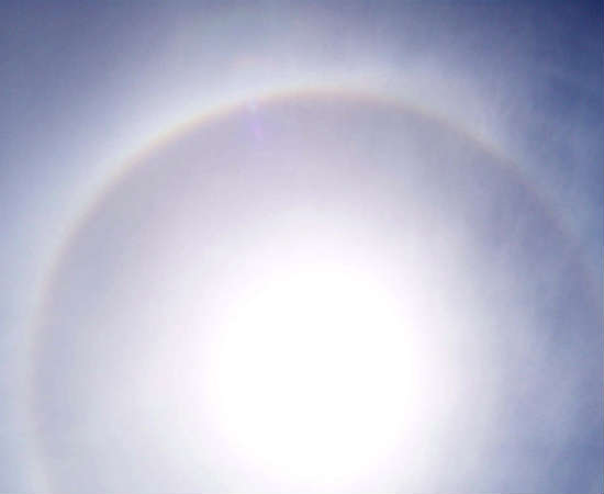 Cirrostratus: estas nuvens se localizam logo abaixo das nuvens cirrus. São finas e leves, a ponto de não encobrirem o sol. Em vez disso, quando estão em frente ao Sol, formam o efeito "halo", este círculo que pode ser visto na foto.