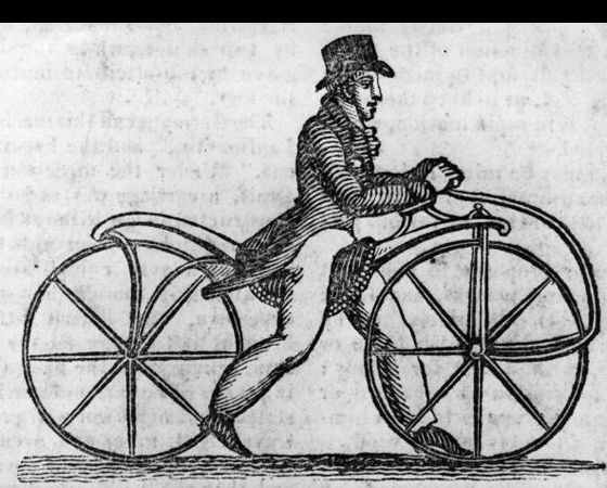 Década de 1810 - PÉS NO CHÃO: O alemão Karl Drais Von Sauerbronn cria um cavalo de madeira, com guidão e duas rodas. A invenção, de 1816, ficou conhecida como draisiana. Era a primeira bicicleta. Mas ainda com tração Flintstones: os pés faziam as vezes de pedal. Entre as décadas de 1820 a 1850, surgem os pedais: rígidos e acoplados diretamente à roda dianteira. Década de 1810 - PÉS NO CHÃO: O alemão Karl Drais Von Sauerbronn cria um cavalo de madeira, com guidão e duas rodas. A invenção, de 1816, ficou conhecida como draisiana. Era a primeira bicicleta. Mas ainda com tração Flintstones: os pés faziam as vezes de pedal. Entre as décadas de 1820 a 1850, surgem os pedais: rígidos e acoplados diretamente à roda dianteira.