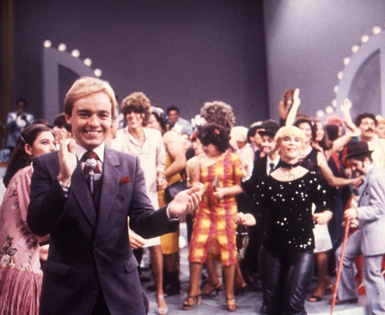 Politicamente correto? Gugu Liberato, o almofadinha do programa Viva a Noite, segundo o Jornal do Brasil, fazia pontas em A Praça é Nossa e era chamado de travesti pela Velha Surda. Politicamente correto? Gugu Liberato, o almofadinha do programa Viva a Noite, segundo o Jornal do Brasil, fazia pontas em A Praça é Nossa e era chamado de travesti pela Velha Surda.