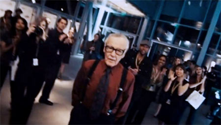 Tony Stark cumprimenta Stan Lee em Homem de Ferro 2 (2010). O quadrinista aprece vestindo uma camisa brilhante, suspensórios e gravata.
