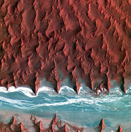 Essa foto extraordin&aacute;ria mostra o deserto da Nam&iacute;bia, na &Aacute;frica. A parte em azul &eacute; o rio Tsauchab, que permanece seco durante boa parte do ano. Os pequenos pontos negros perto do rio s&atilde;o diferentes tipos de vegeta&ccedil;&atilde;o.