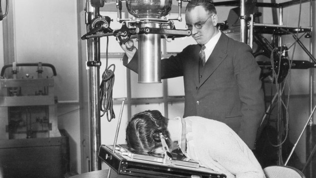 1931: Para demonstrar as últimas novidades no campo da radiografia, uma voluntária tem a cabeça exposta a raios x durante um congresso médico em Londres.