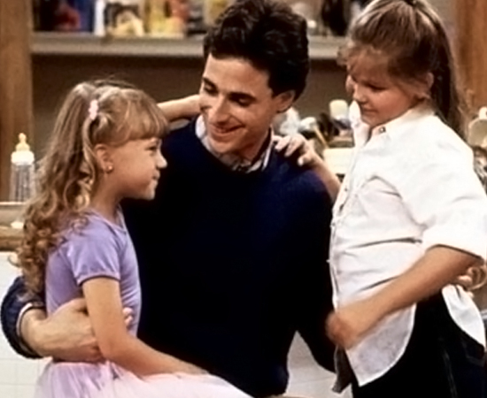 DANNY TANNER (Três é Demais) - Após ficar viúvo, ele cuida de suas três filhas: Michelle, DJ e Stephanie. A tarefa não é simples, mas, a cada episódio, Danny se torna um pai ainda melhor e mais atencioso.