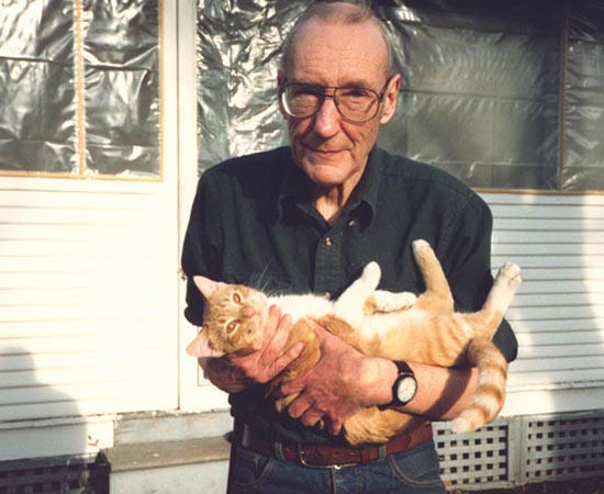 William S. Burroughs segura seu gatinho Ginger. Ele foi um dos autores mais famosos da Geração Beat. Escreveu Almoço Nu e E Os Hipopótamos Foram Cozidos Em Seus Tanques.