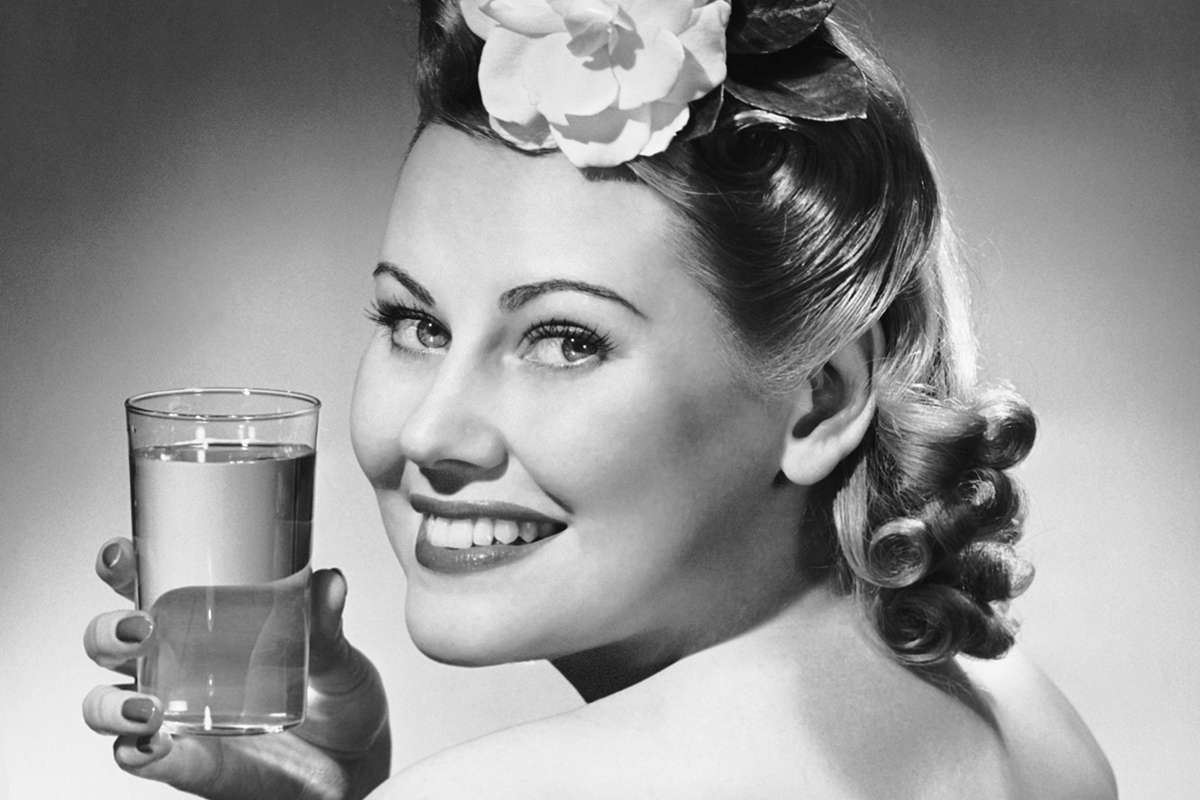 Portrait of woman holding glass of water