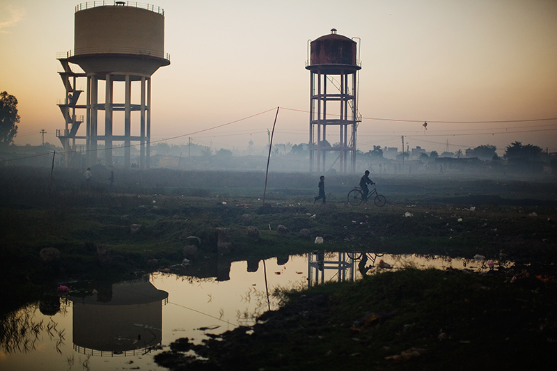 BHOPAL, INDIA - NOVEMBER 27: Children play near water towers in front of their homes near the Union Carbide factory on November 27, 2009 in Bhopal, India. Twenty-five years after an explosion causing a mass gas leak, in the Union Carbide factory in Bhopal, killed at least eight thousand people, toxic material from the biggest industrial disaster in history continues to affect Bhopalis. A new generation is growing up sick, disabled and struggling for justice. The effects of the disaster on the health of generations to come, both through genetics, transferred from gas victims to their children and through the ongoing severe contamination, caused by the Union Carbide factory, has only started to develop visible forms recently. (Photo by Daniel Berehulak/Getty Images)