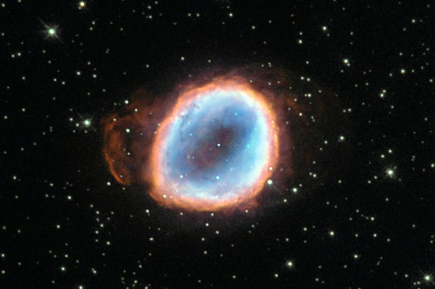 Essa estrela, que também tem magnitude parecida com a do Sol, deu origem à nebulosa NGC 6565. Depois de ejetar suas camadas anteriores, seu centro luminoso ficou exposto, produzindo radiação ultravioleta. A luz excita as camadas de gás ao redor, formando o espetáculo cósmico de cores.