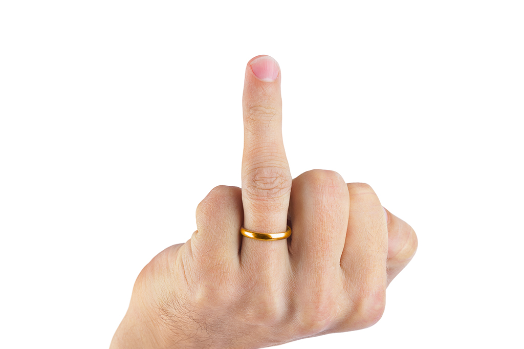 Close up de um pernilongo picando o dedo de uma pessoa.