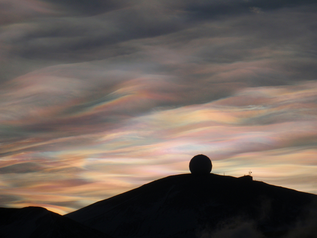 A foto mostra um fenômeno atmosférico raro que deixa as nuvens com uma aparência ondulada e multicolorida.