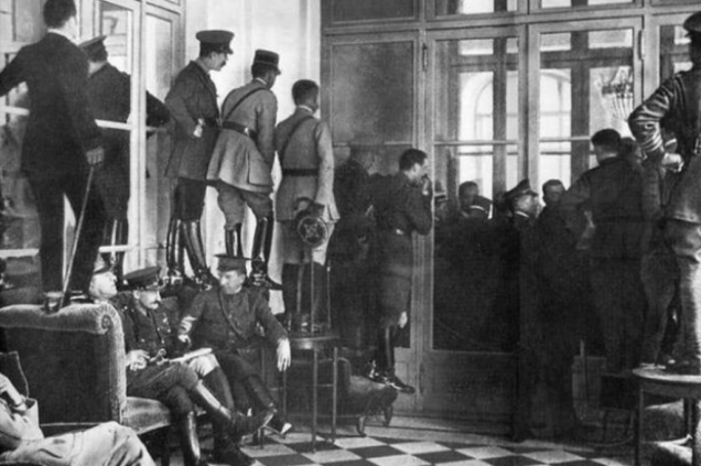 Pessoas sobem nas cadeiras para testemunhar a assinatura do Tratado de Versalhes, em 1919, que encerrou a Primeira Guerra Mundial.