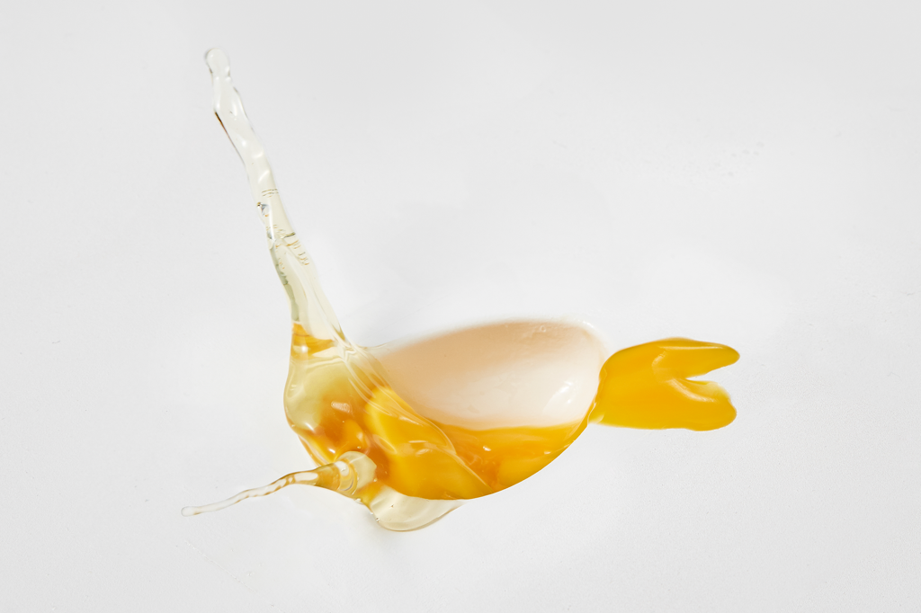 Imagem de uma gema e clara de ovo no ar, em movimento