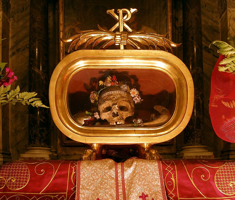 Crânio atribuído a São Valentim rodeado por flores e dentro de uma urna dourada
