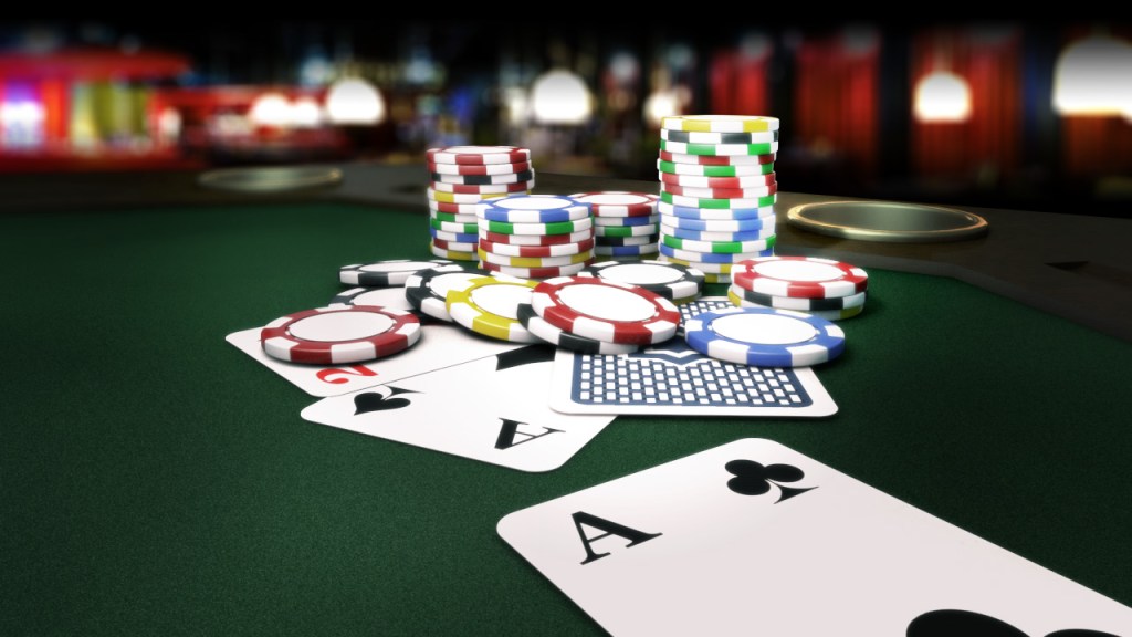 Cartas de baralho e fichas de poker sobre uma mesa.