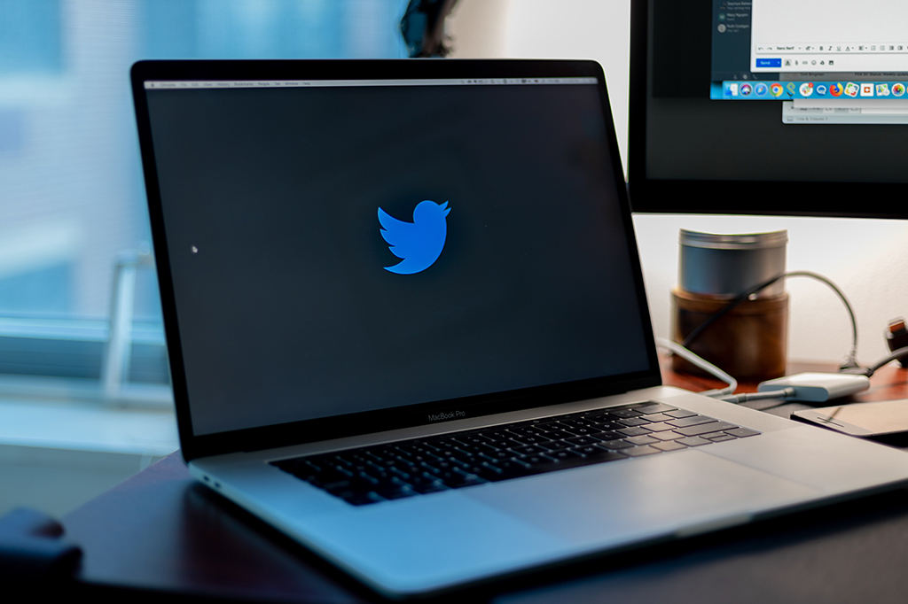 Notebook aberto com o logo do twitter centralizado na tela.