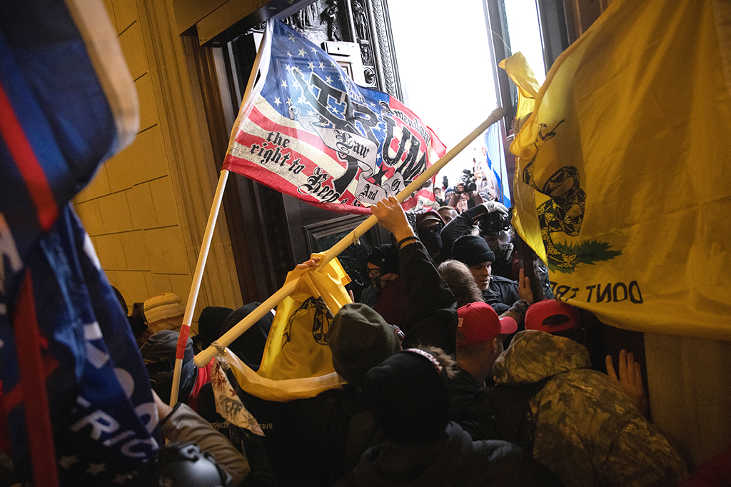 QAnon e tribalismo masculino: a extrema direita por trás da invasão do Capitólio Uma multidão pró-Trump invadindo o Capitólio dos EUA.