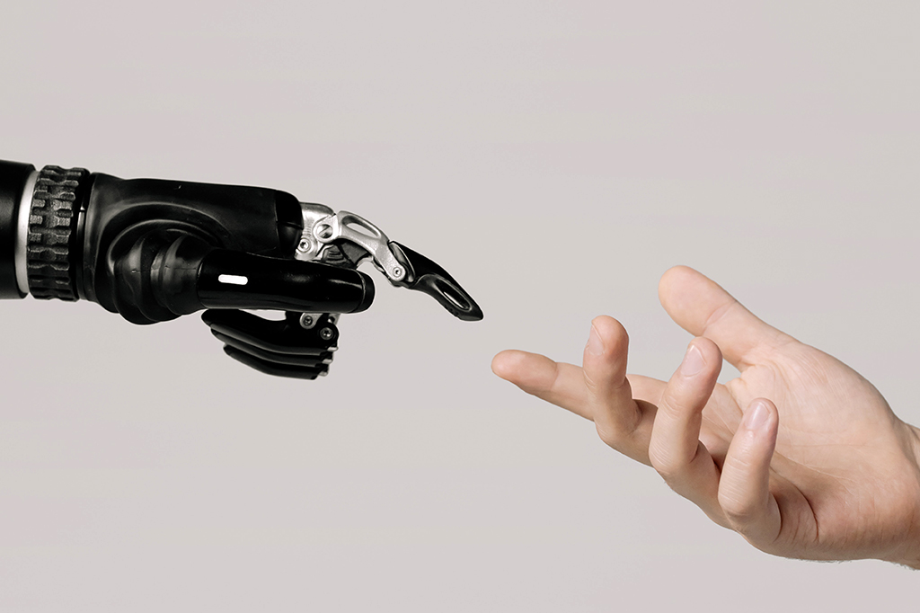 Mão robótica interagindo com uma mão humana.