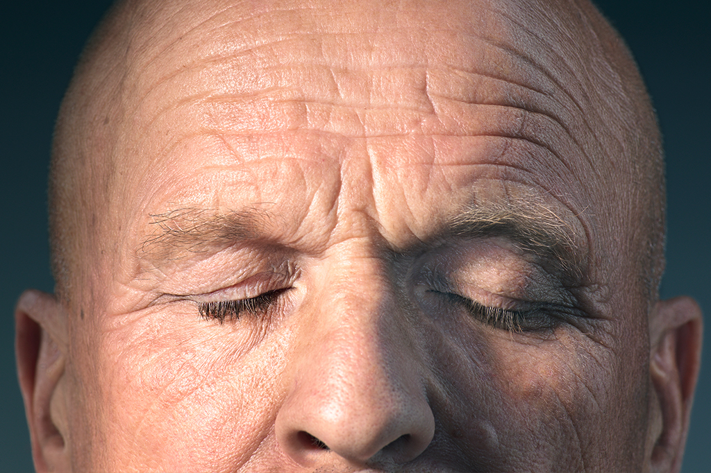Foto mostrando um zoom do rosto de um homem de olhos fechados.