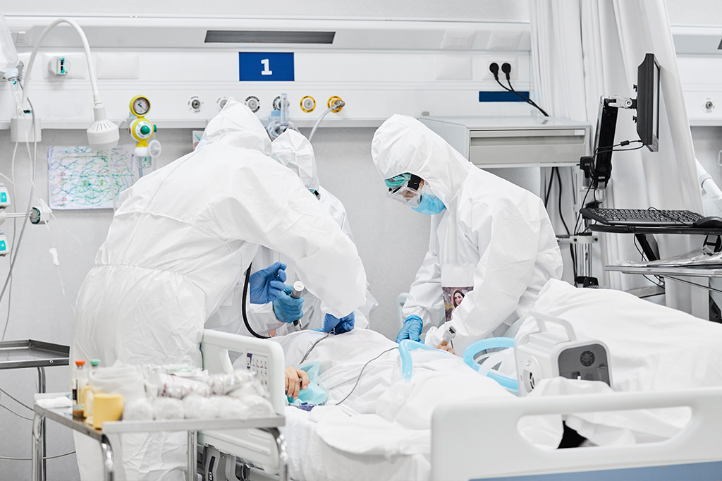 Grupo de médicos entubando um paciente internado.