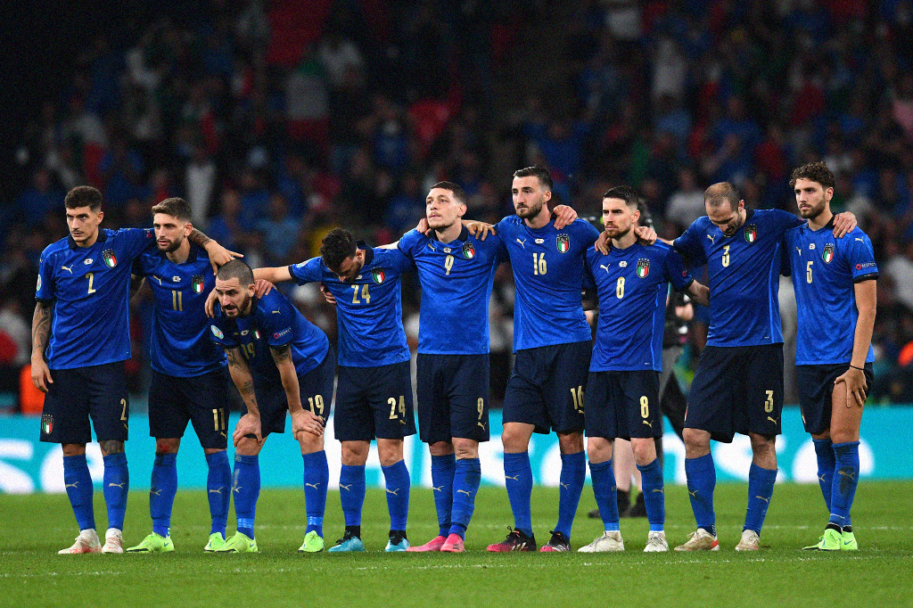 Jogadores da seleção da Itália abraçados com tensão durante os pênaltis.
