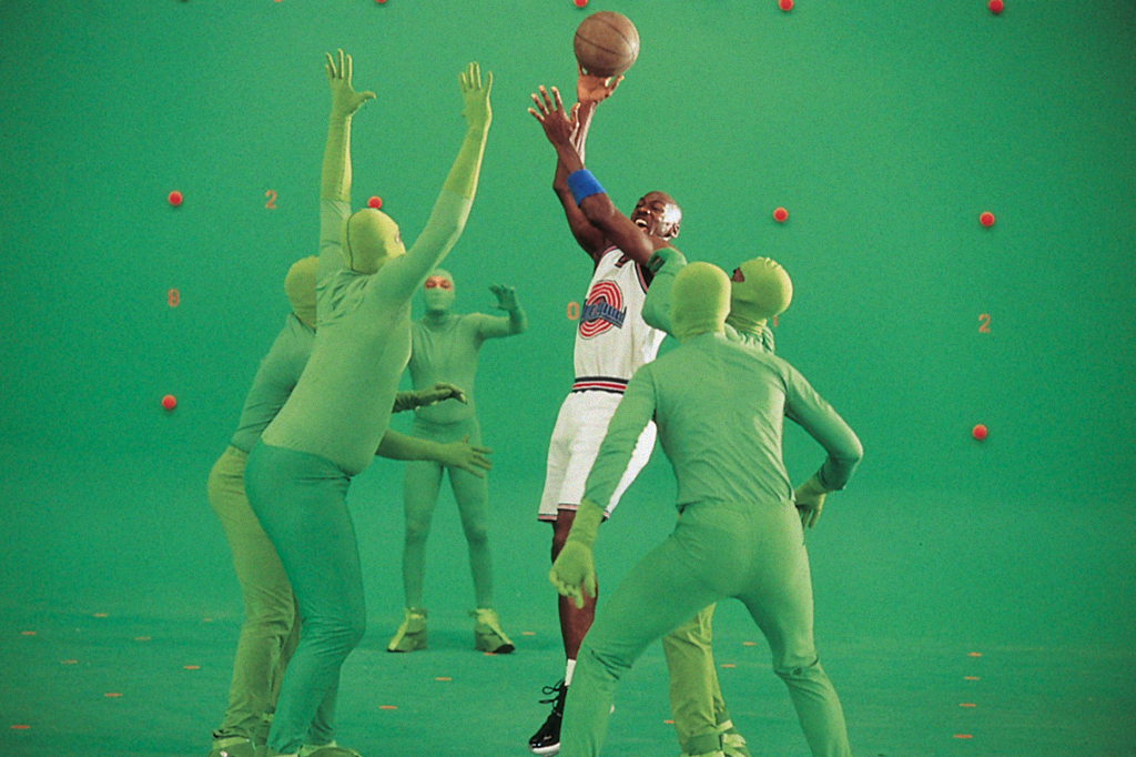 Foto de Michael Jordan filmando Space Jam ao lado de pessoas usando roupas verdes.