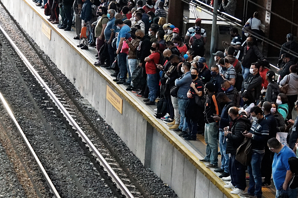 Foto mostrando uma das estações da CPTM de São Paulo lotada, com pessoas usando máscaras.