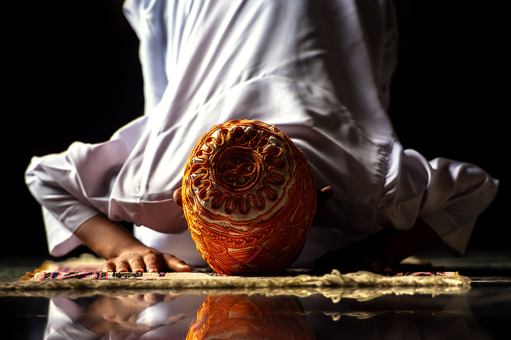 Foto de muçulmano agachado rezando.