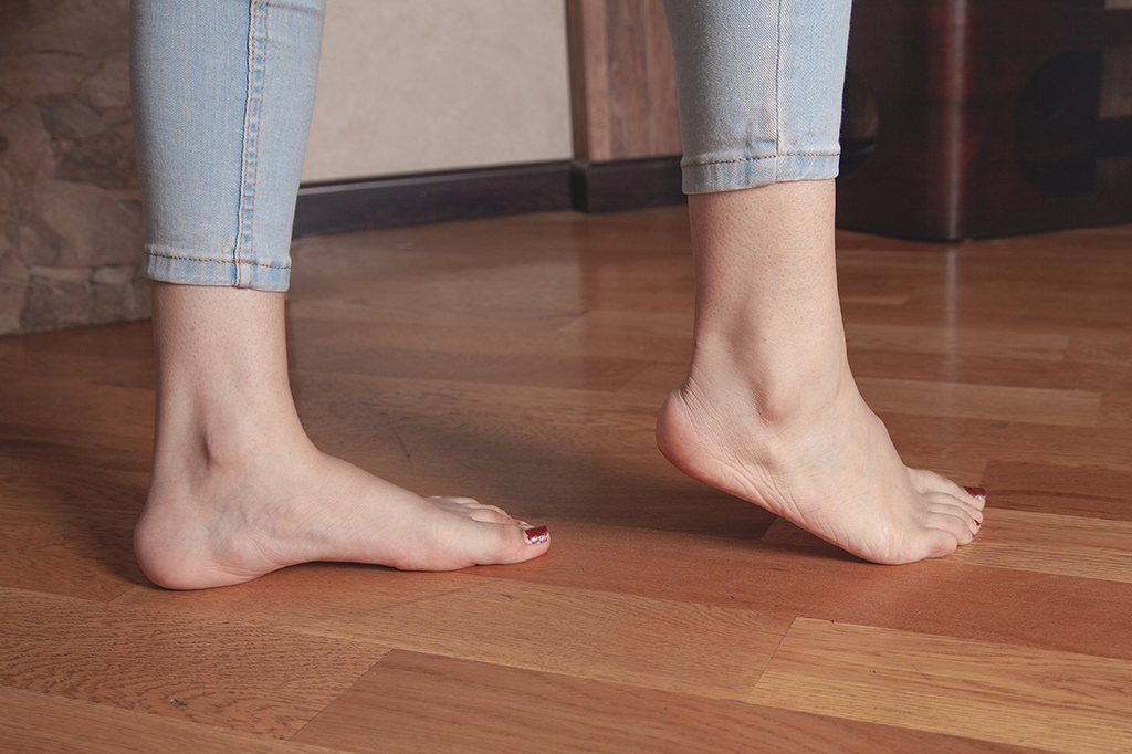 Imagem de pés pisando em chão de madeira