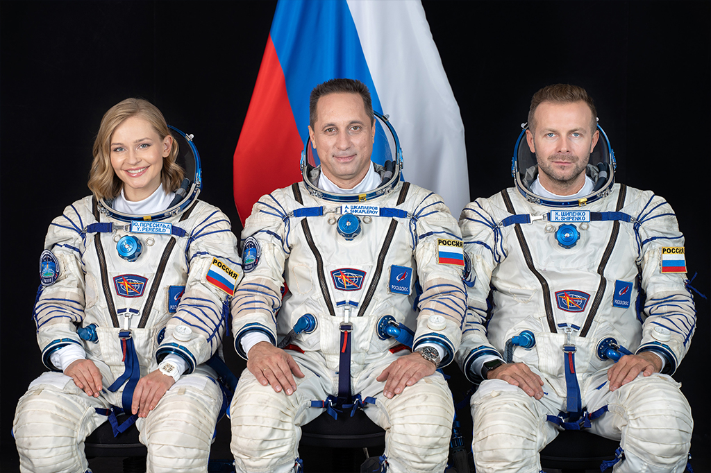 A atriz Yulia Peresild, o astronauta Anton Shkaplerov e o diretor Klim Shipenko posam com trajes espaciais.