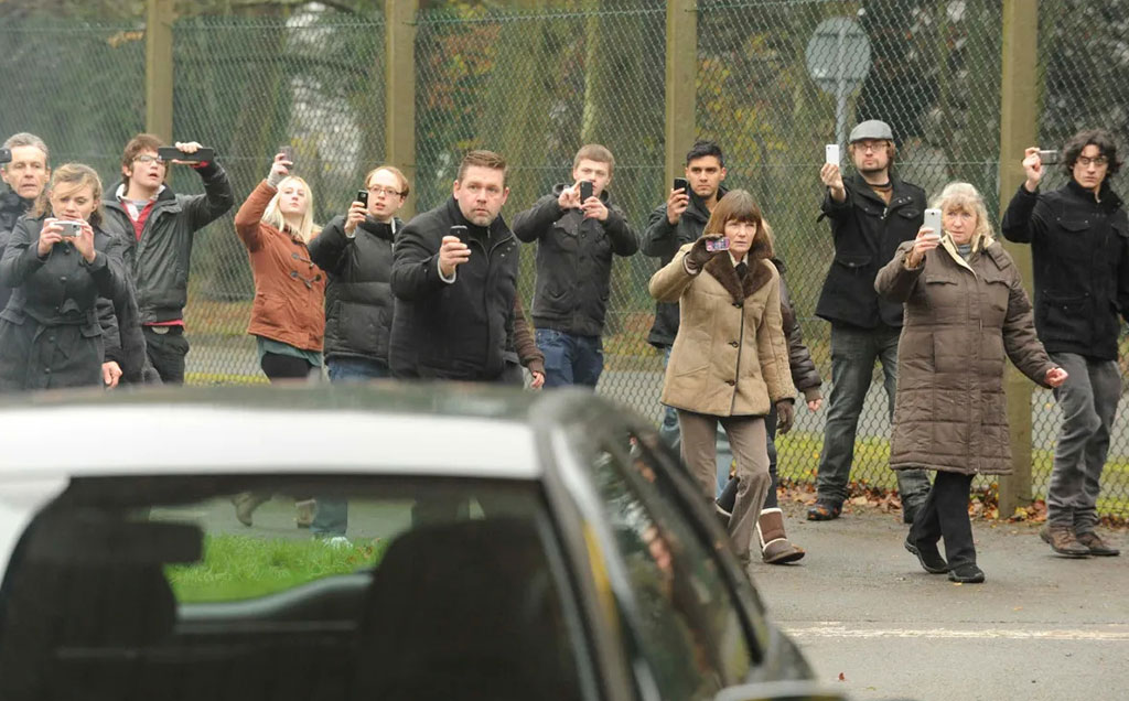 Cena da série Black Mirror, da Netflix, com várias pessoas com celulares na mão filmando um acontecimento