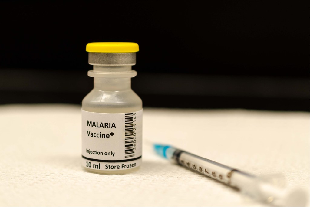 fotografia de um frasco contendo a vacina da malária com uma seringa ao lado