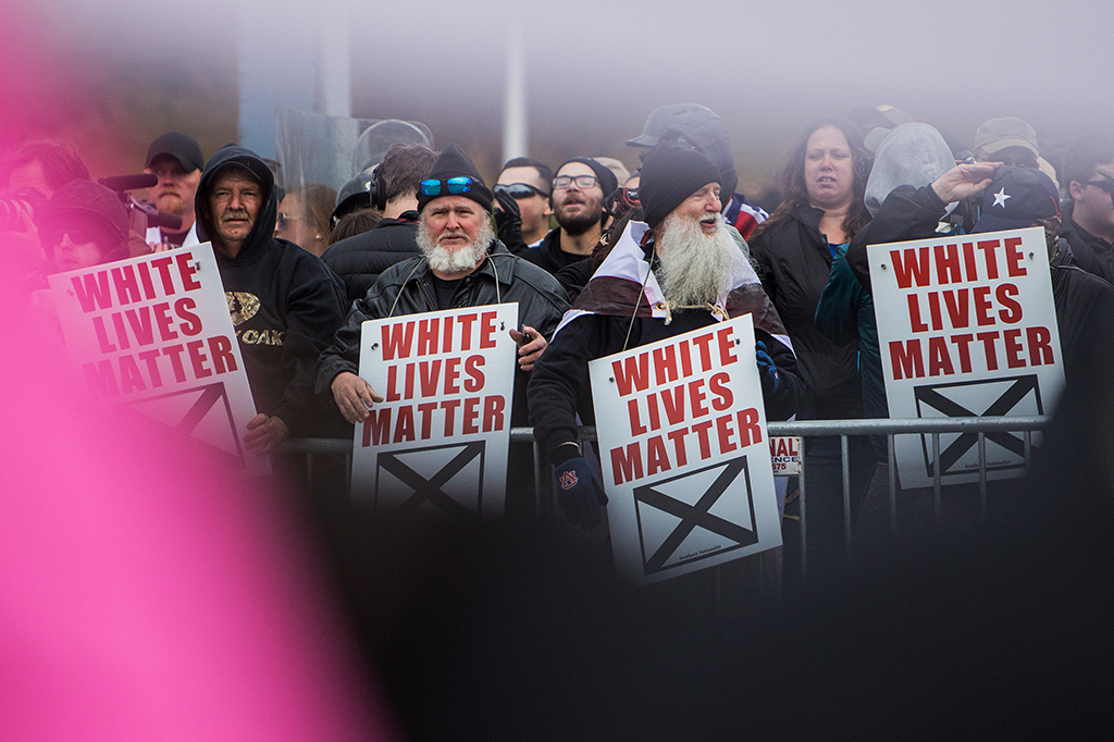 Protestantes segurando placas escritas "white lives matter".