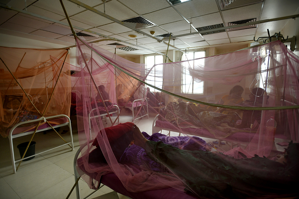 Pacientes em ala para tratamento de dengue num hospital indiano.
