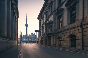 Imagem de uma rua vazia de Xangai, com a silhueta da Torre de Pérola ao fundo.