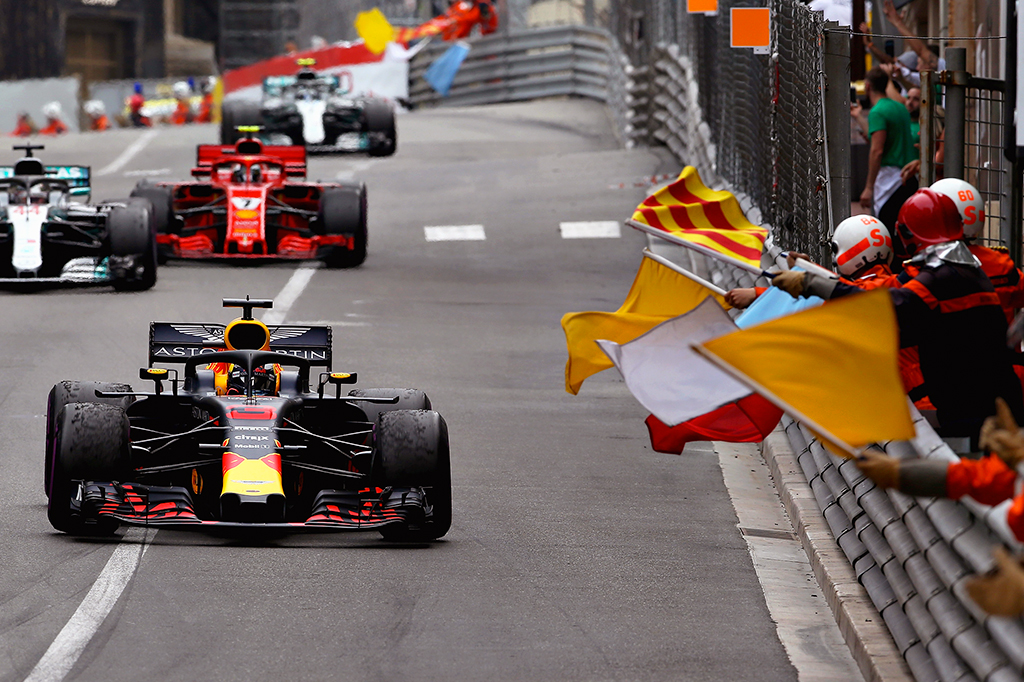 Foto de marechais segurando bandeiras da Formula 1 no fim de uma corrida.