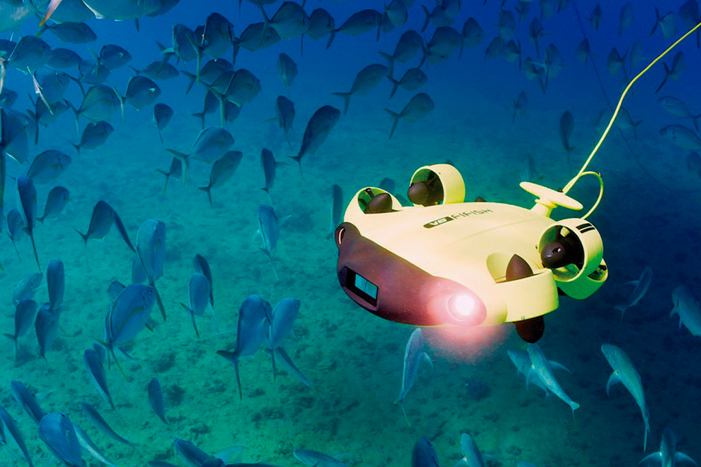 Drone submarino submerso no oceano, com peixes nadando em volta.