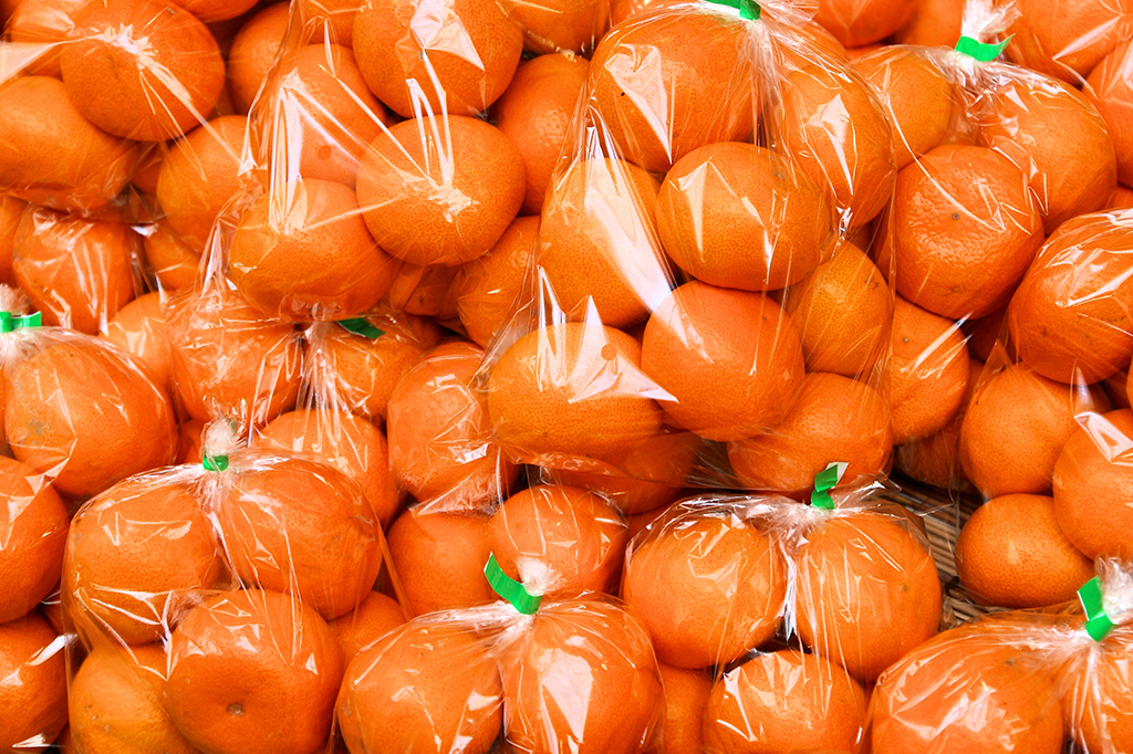 Múltiplas frutas pokans envolvidas em embalagens plásticas.