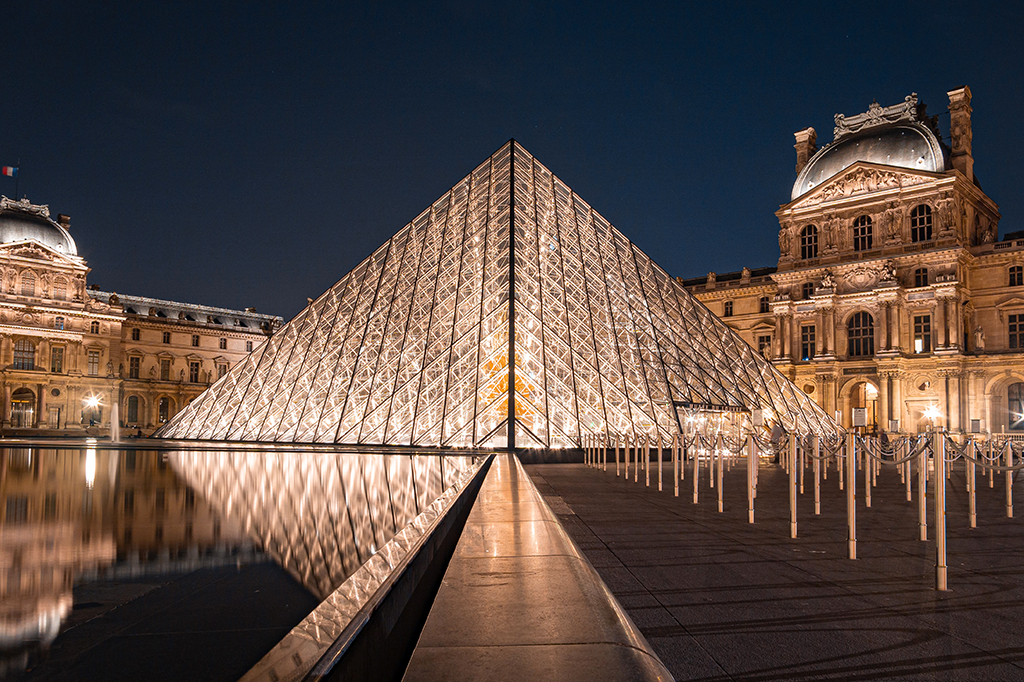 Foto do Louvre durante a noite.