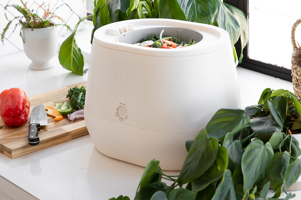 Composteira Lomi na bancada de uma cozinha, com resíduos orgânicos.