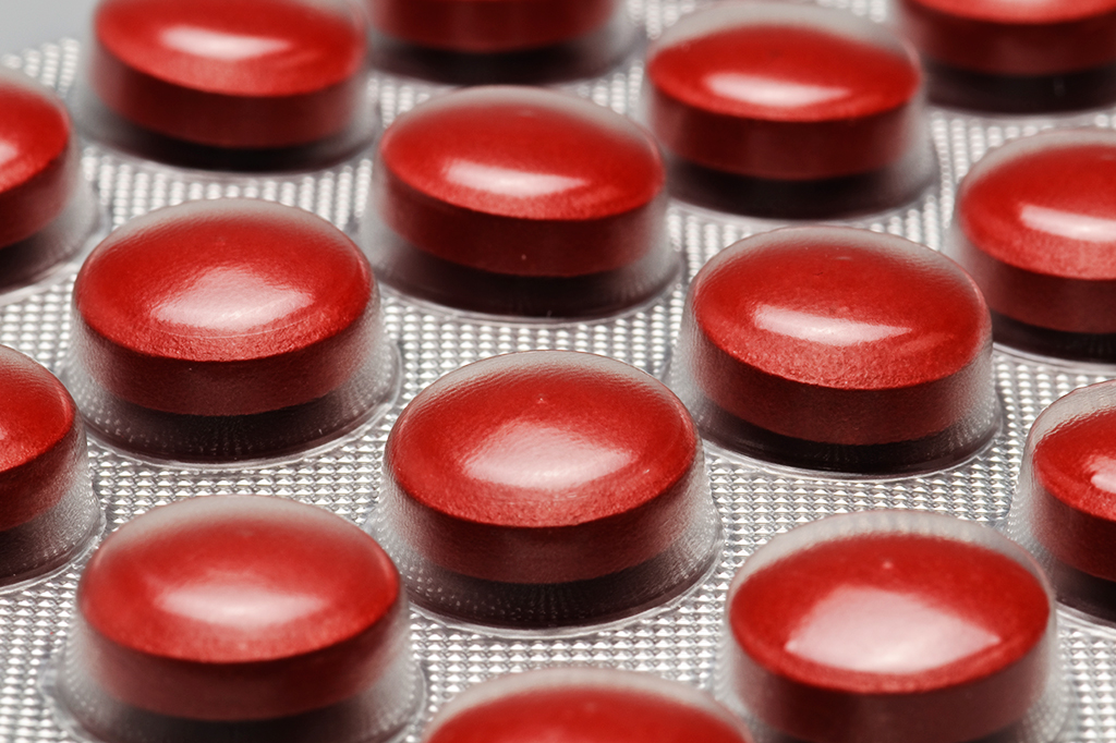 Fotografia close up de comprimidos vermelhos em uma cartela (suplemento de ferro).
