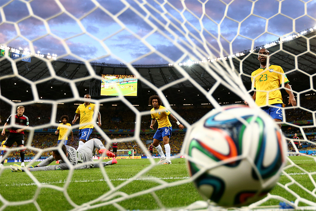 Jogadores vendo a bola afundar a rede brasileira em mais um gol da Alemanha, um dos 7-1, na Copa do Mundo de 2014.