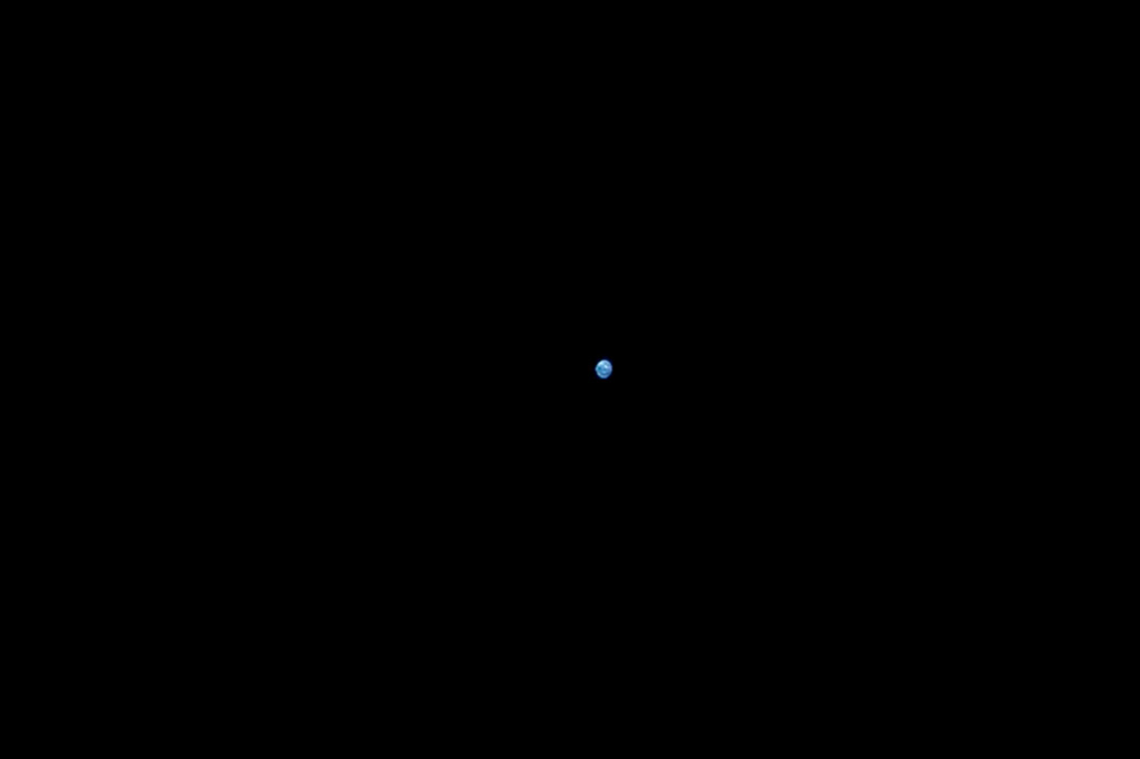 Tirada da câmera solar de Orion, a Terra é vista ao longe.