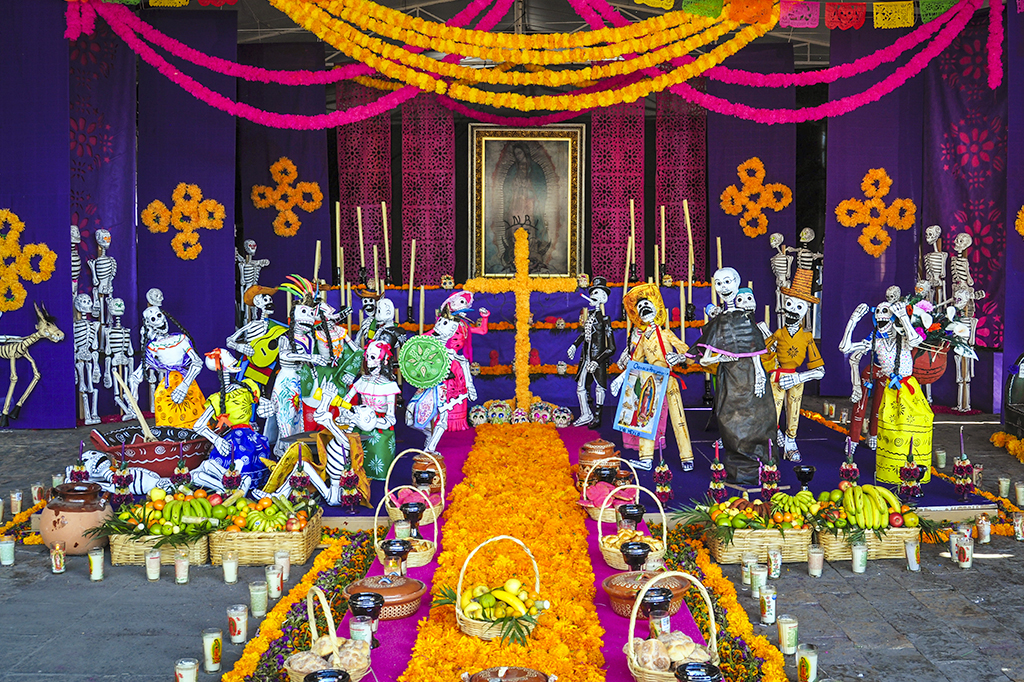Día de los Muertos: conheça a origem e as tradições do feriado mexicano Foto de um altar para o dia dos mortos com oferendas, flores, caveiras e bandeiras.