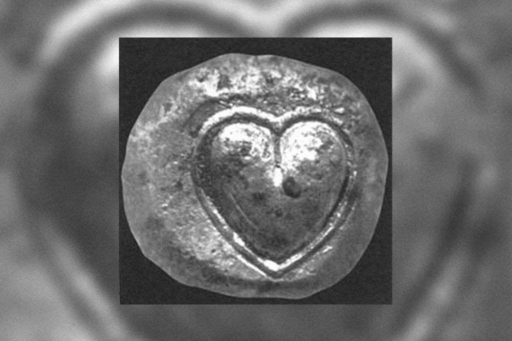 Moeda de prata antiga com um símbolo de coração.