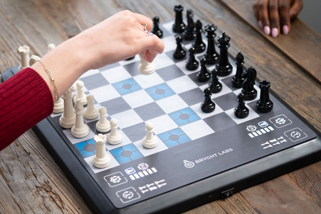 Close do tabuleiro de xadrez ChessUp com duas pessoas jogando.