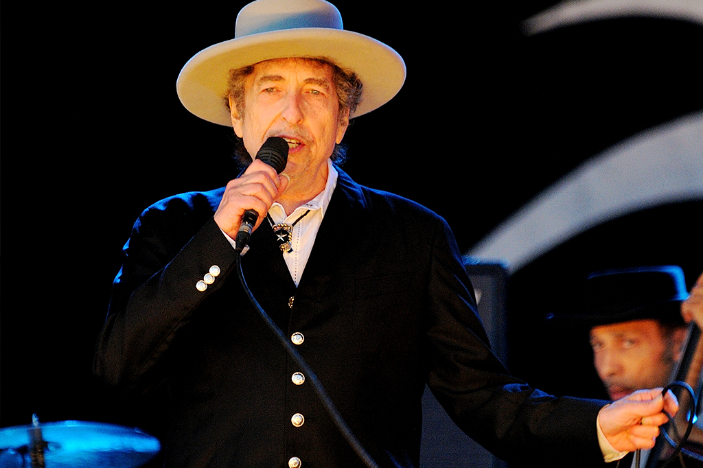 Bob Dylan em show, segurando microfone.