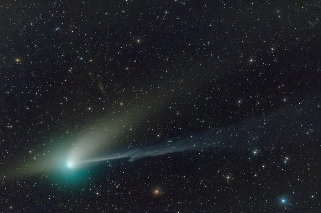 Fotografia do cometa no céu estrelado.