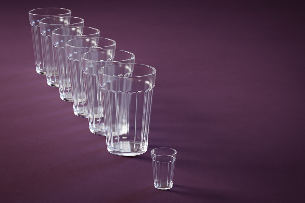 Ilustração de copos de vidro: um menorzinho à frente de um grupo de copos maiores, suas réplicas.