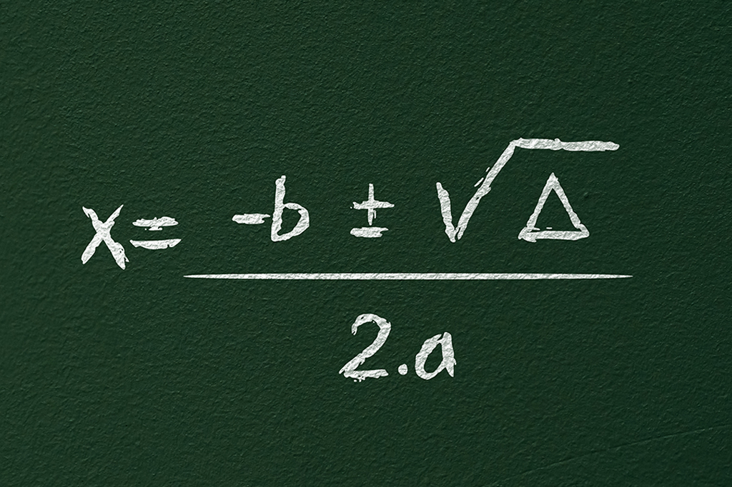 Fotografia da Fórmula de Bhaskara escrita com giz em um quadro.