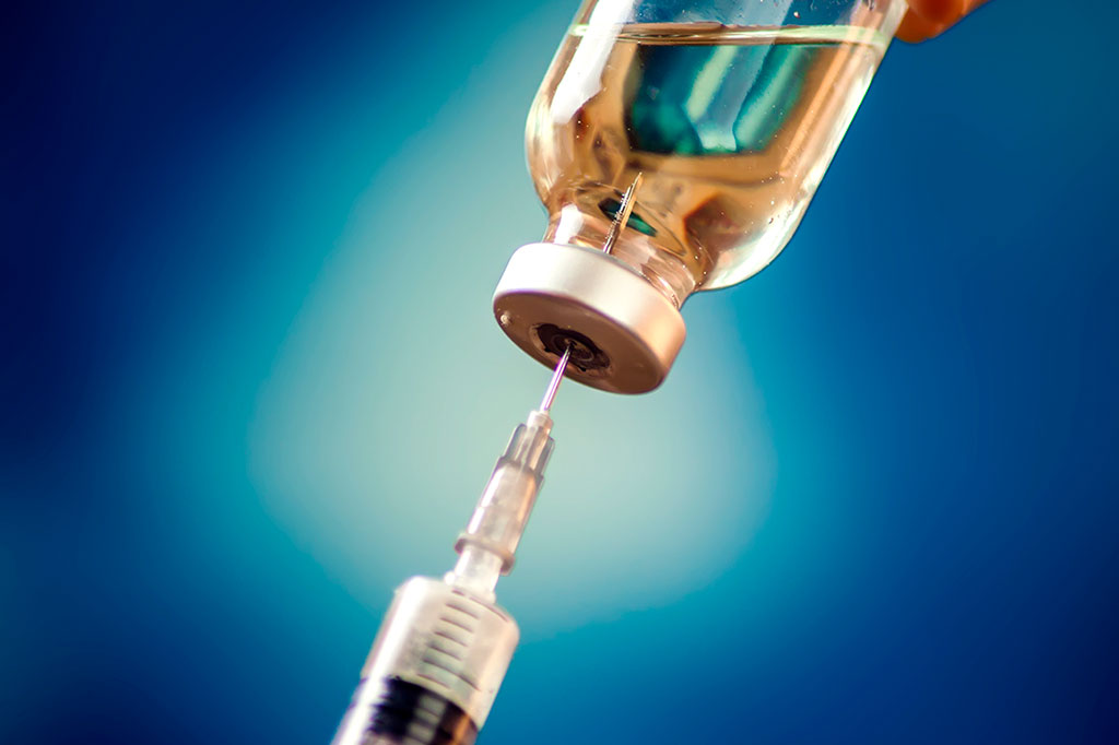 Foto aproximada de uma seringa perfurando a ampola de medicamento em fundo azul.