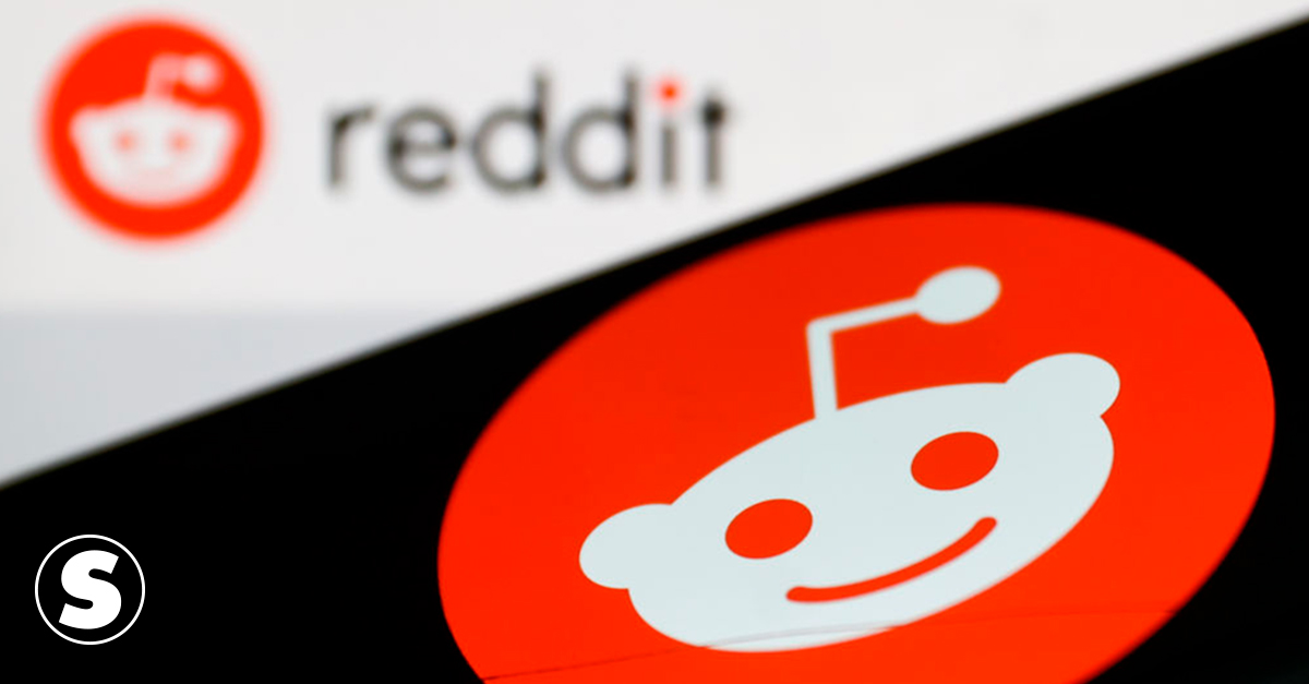 Imagem do logotipo do Reddit exibido na tela de um telefone e ao fundo.